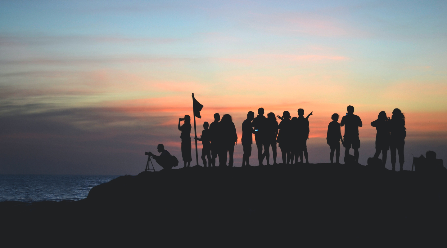 group of people hiking at sunset