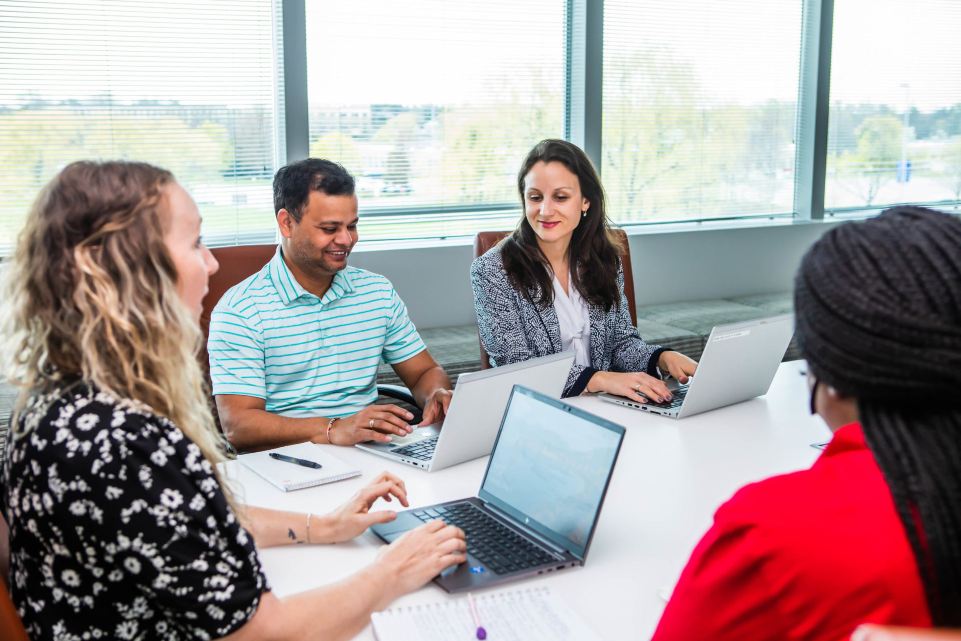 employees in a conference room with laptops